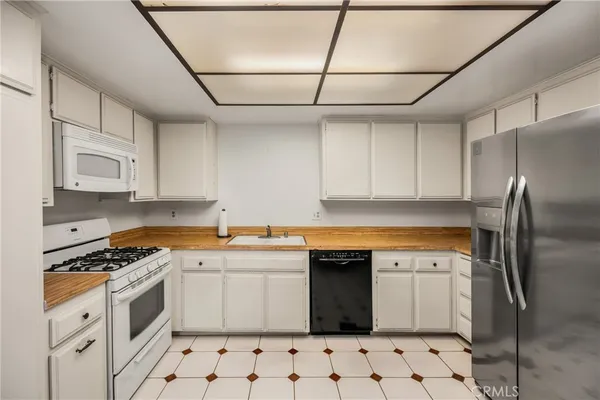 a kitchen with stainless steel appliances a stove a sink and a refrigerator
