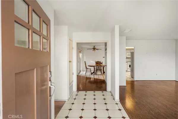 a view of a hallway with wooden floor and a living room