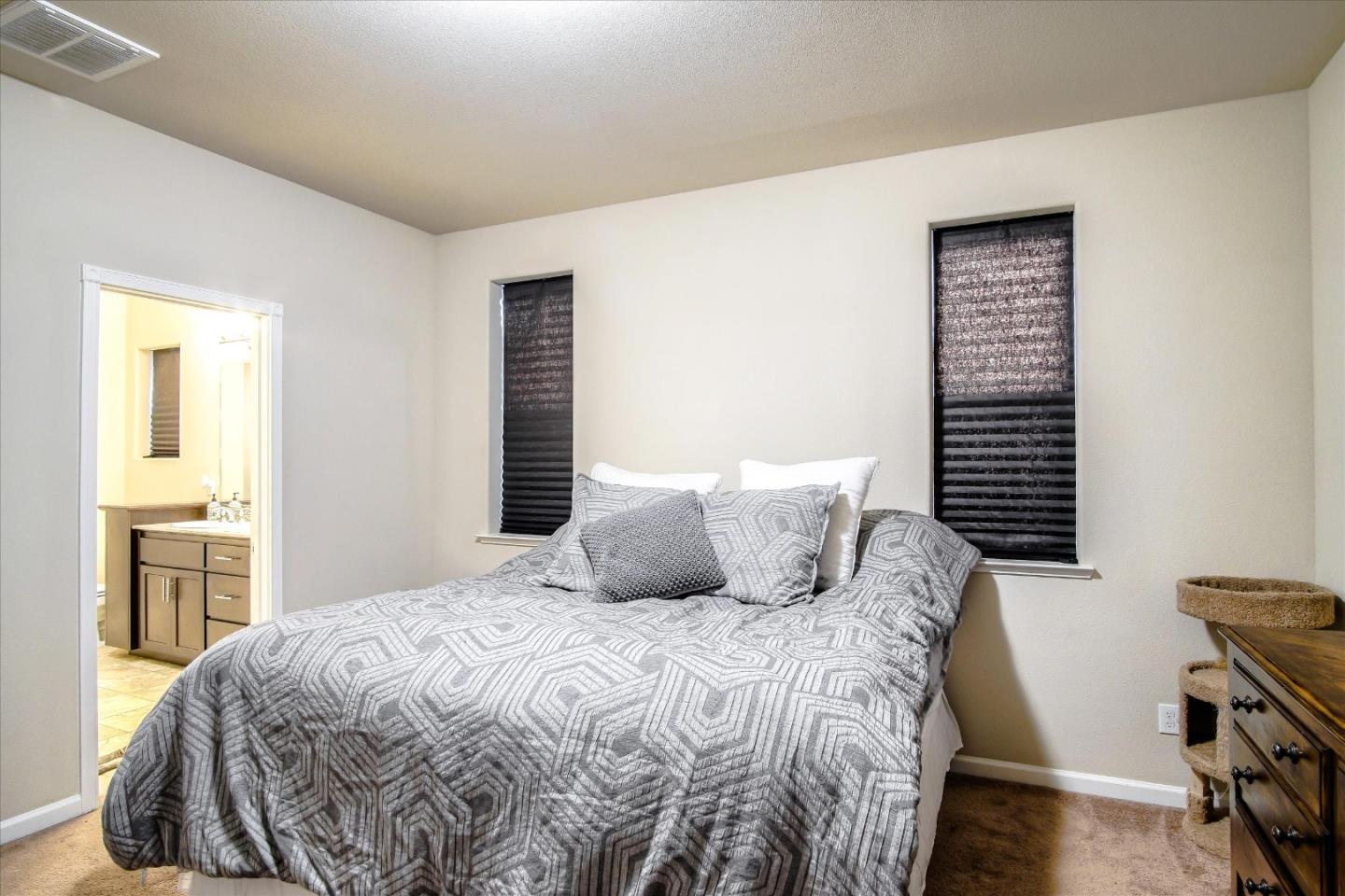 108 Springtime Circle Hollister, CA 95023 - Photo 12 of 36 a bedroom with a large bed and a chandelier