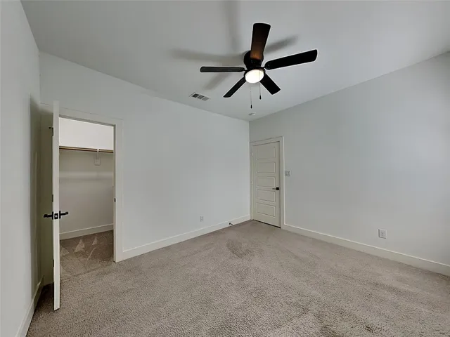 a view of a room with a ceiling fan and a ceiling fan