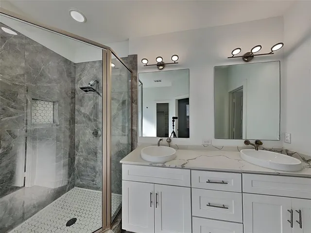 a bathroom with a granite countertop sink a mirror a shower and a bathtub