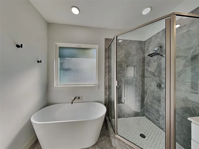 a white bath tub sitting next to a shower