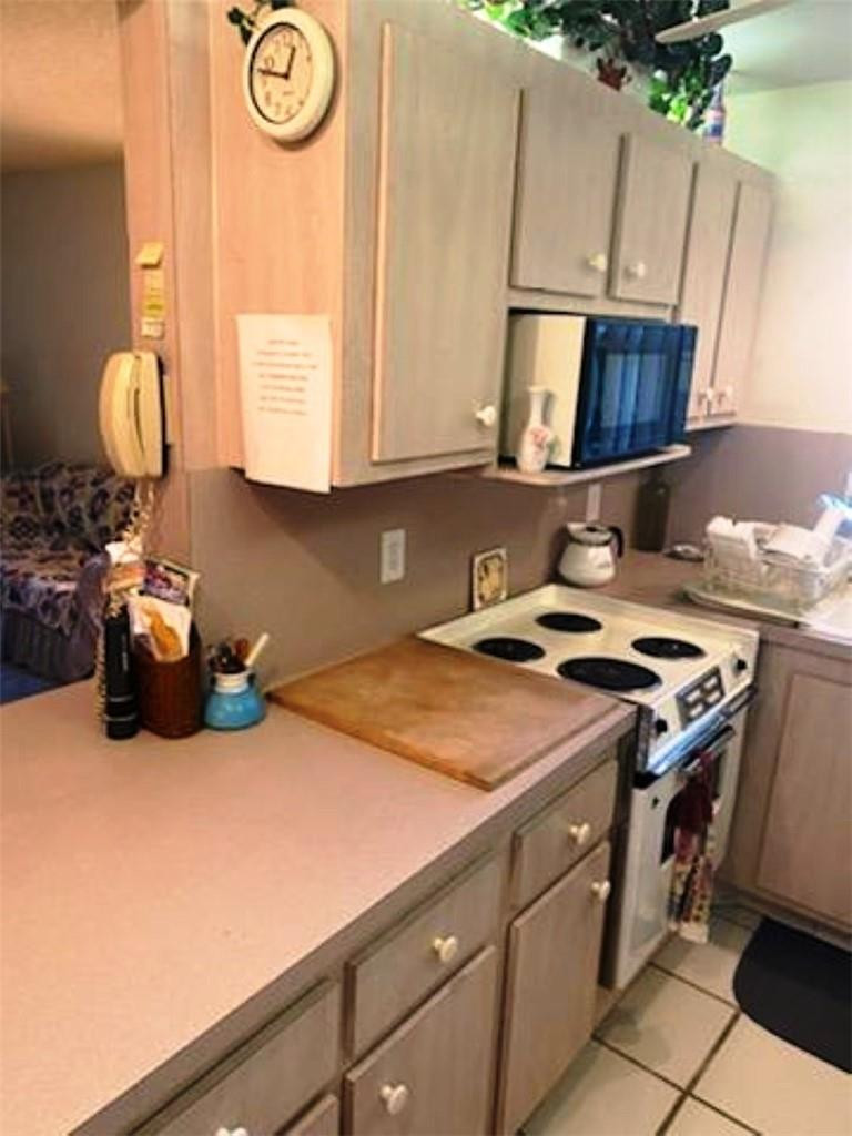 1124 Northwest 13th Street, Unit 106A Boca Raton, FL 33486 - Photo 2 of 8 a kitchen that has a sink and a stove