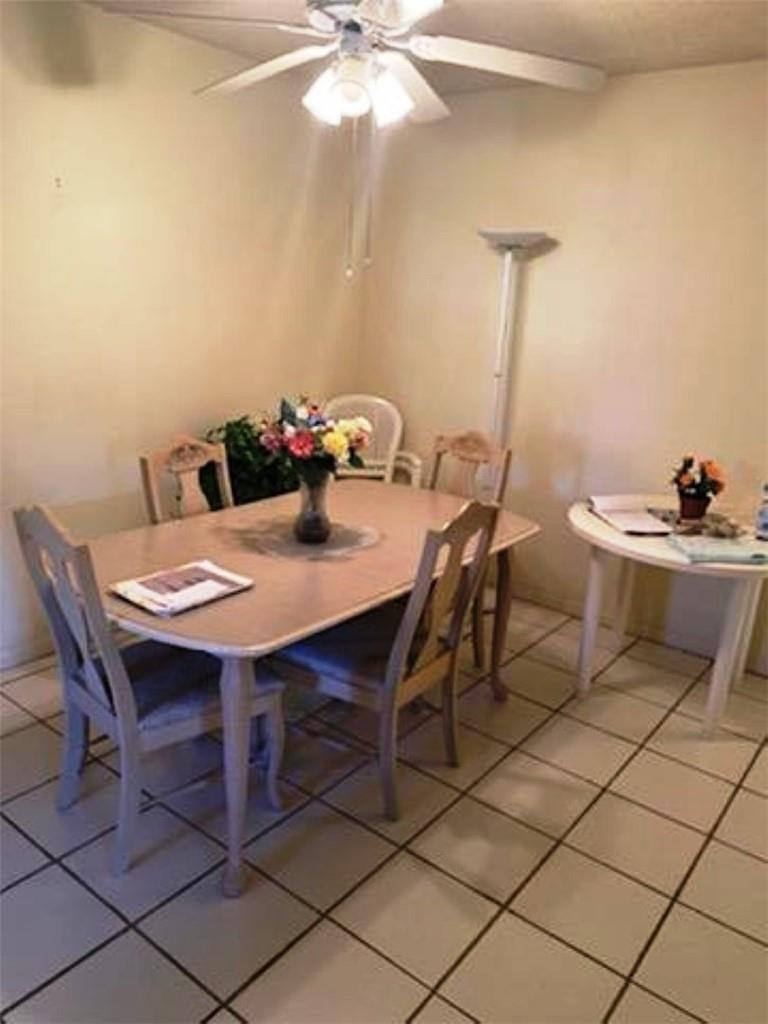 1124 Northwest 13th Street, Unit 106A Boca Raton, FL 33486 - Photo 4 of 8 a view of a dining room with furniture and chandelier