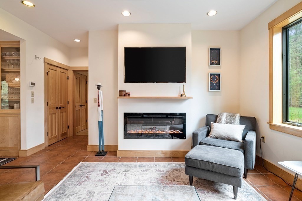 62 Buffam Road Pelham, MA 01002 - Photo 7 of 42 a living room with furniture a flat screen tv and a fireplace