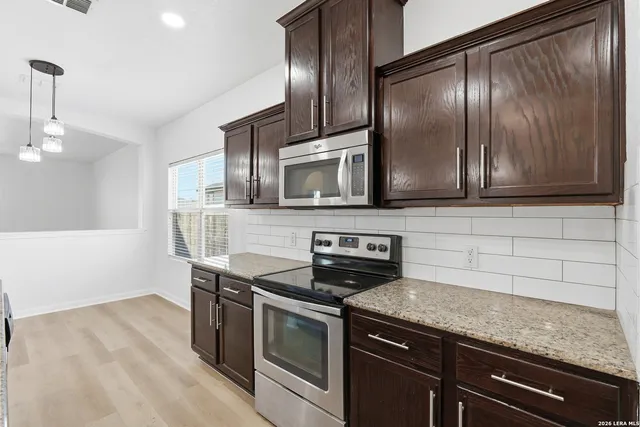a kitchen with stainless steel appliances granite countertop a stove a microwave and a sink