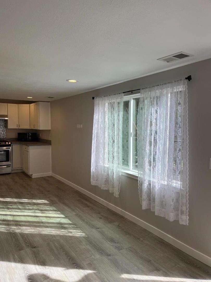 5 Malavear Court, Unit INLAW Pacifica, CA 94044 - Photo 6 of 13 a view of a livingroom with wooden floor and a kitchen