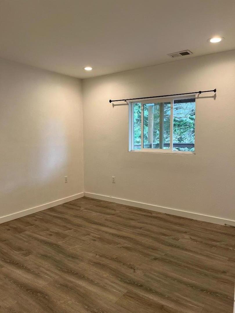 5 Malavear Court, Unit INLAW Pacifica, CA 94044 - Photo 7 of 13 an empty room with wooden floor and windows