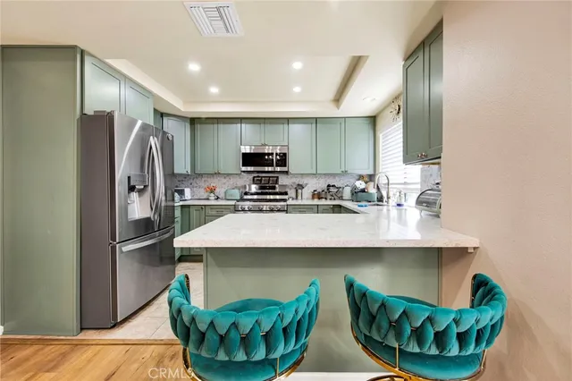 a kitchen with kitchen island stainless steel appliances a sink stove and refrigerator