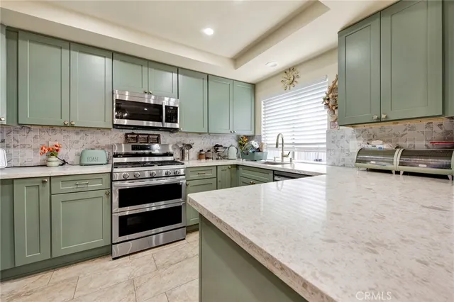 a kitchen with stainless steel appliances a stove sink and microwave