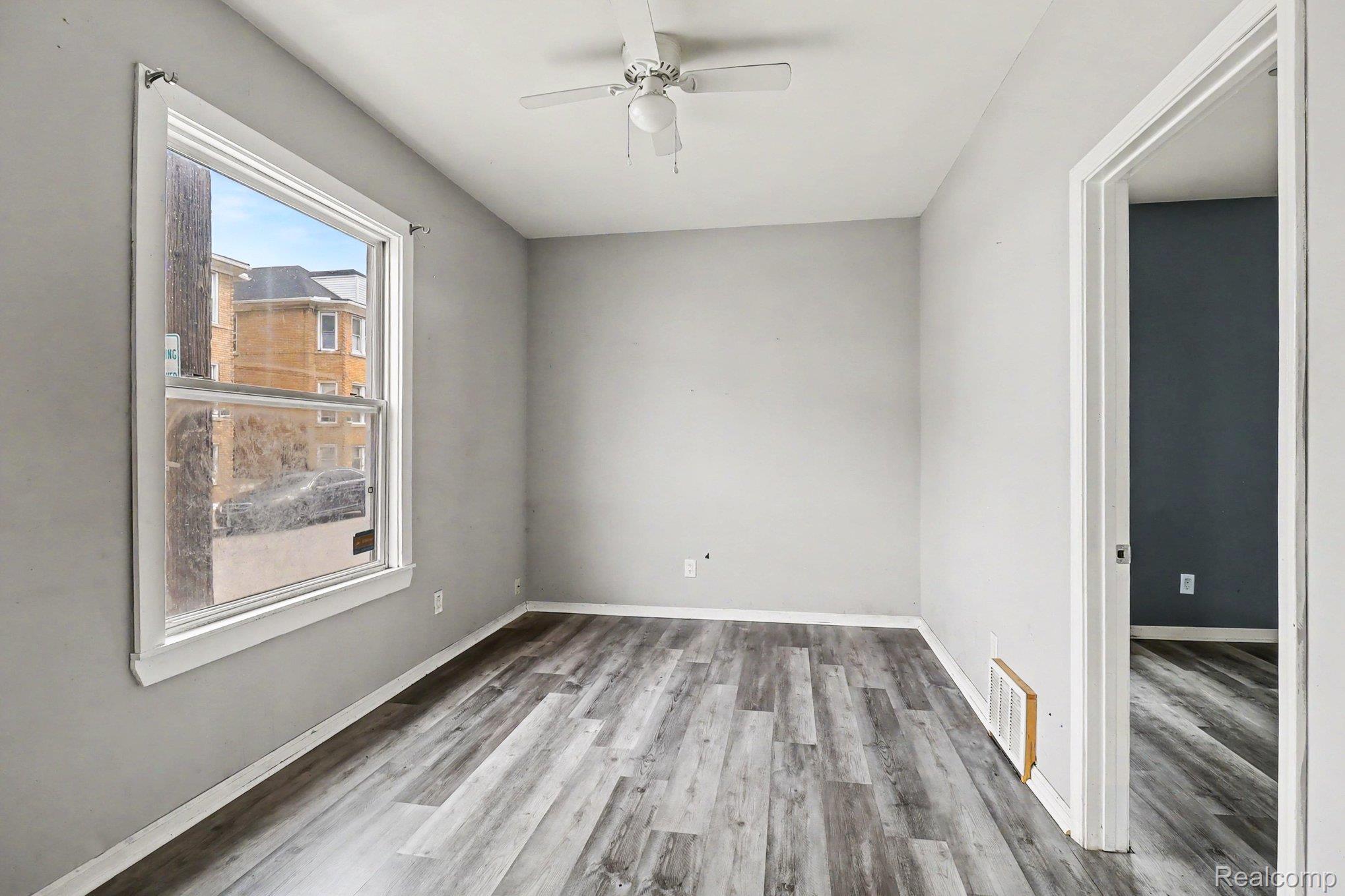 7743 Pitt Street Detroit, MI 48209 - Photo 5 of 15 Room featuring wood-finish flooring, a ceiling fan, and a double-hung window