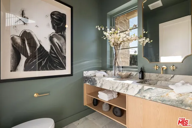 a bathroom with a granite countertop sink and a mirror