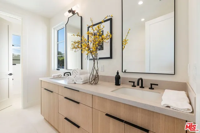 a bathroom with double vanity sink a mirror and a shower