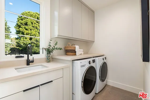 a utility room with sink dryer and washer