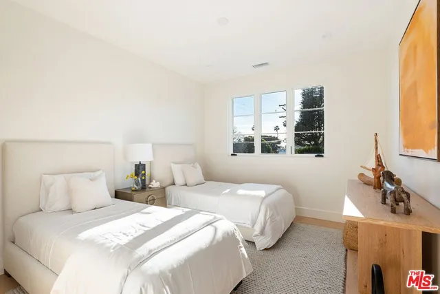 a bedroom with two beds and a window