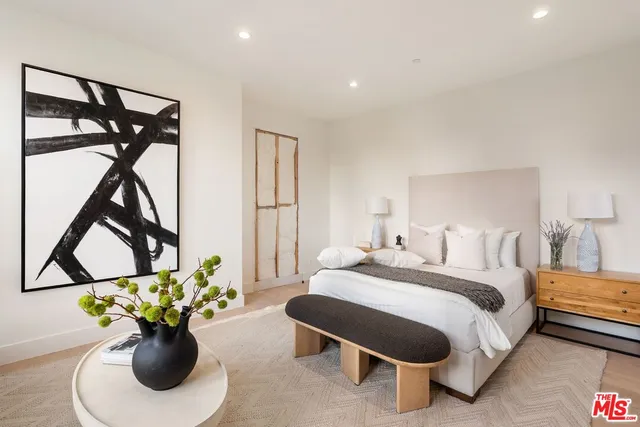 a bedroom with a bed table and a potted plant
