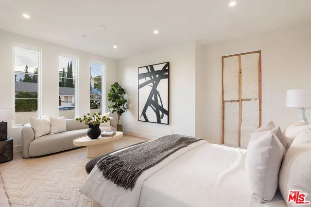 a bedroom with a bed couch and window