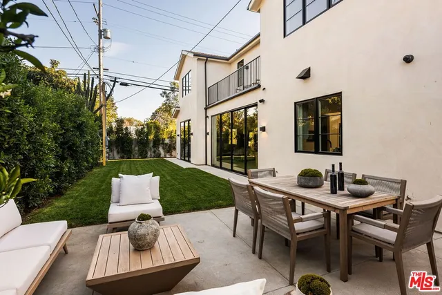 a view of a patio with couches table and chairs and potted plants
