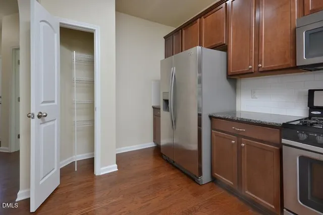 a kitchen with stainless steel appliances granite countertop a refrigerator and a stove