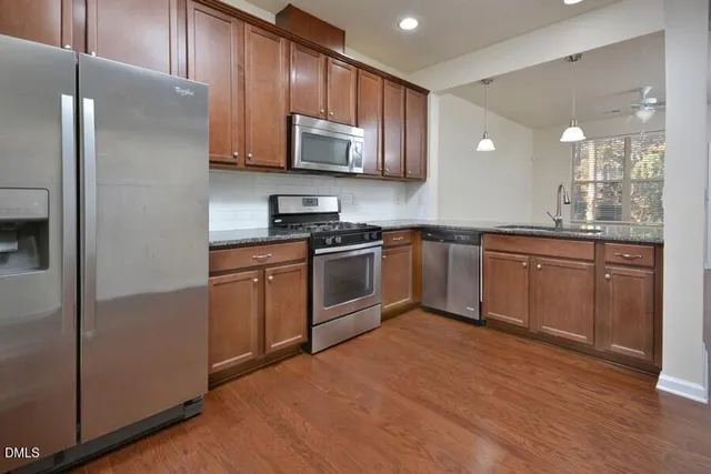 a kitchen with stainless steel appliances granite countertop a stove a sink dishwasher and a refrigerator