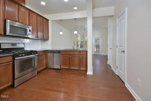 a kitchen with stainless steel appliances granite countertop a stove a sink and a refrigerator