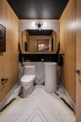 a bathroom with a toilet a sink and mirror