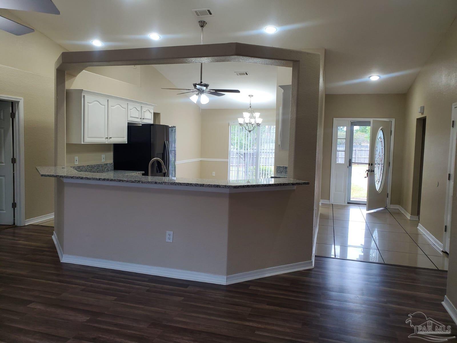 659 Griswold Road Jay, FL 32565 - Photo 8 of 42 an open kitchen with wooden floor and refrigerator