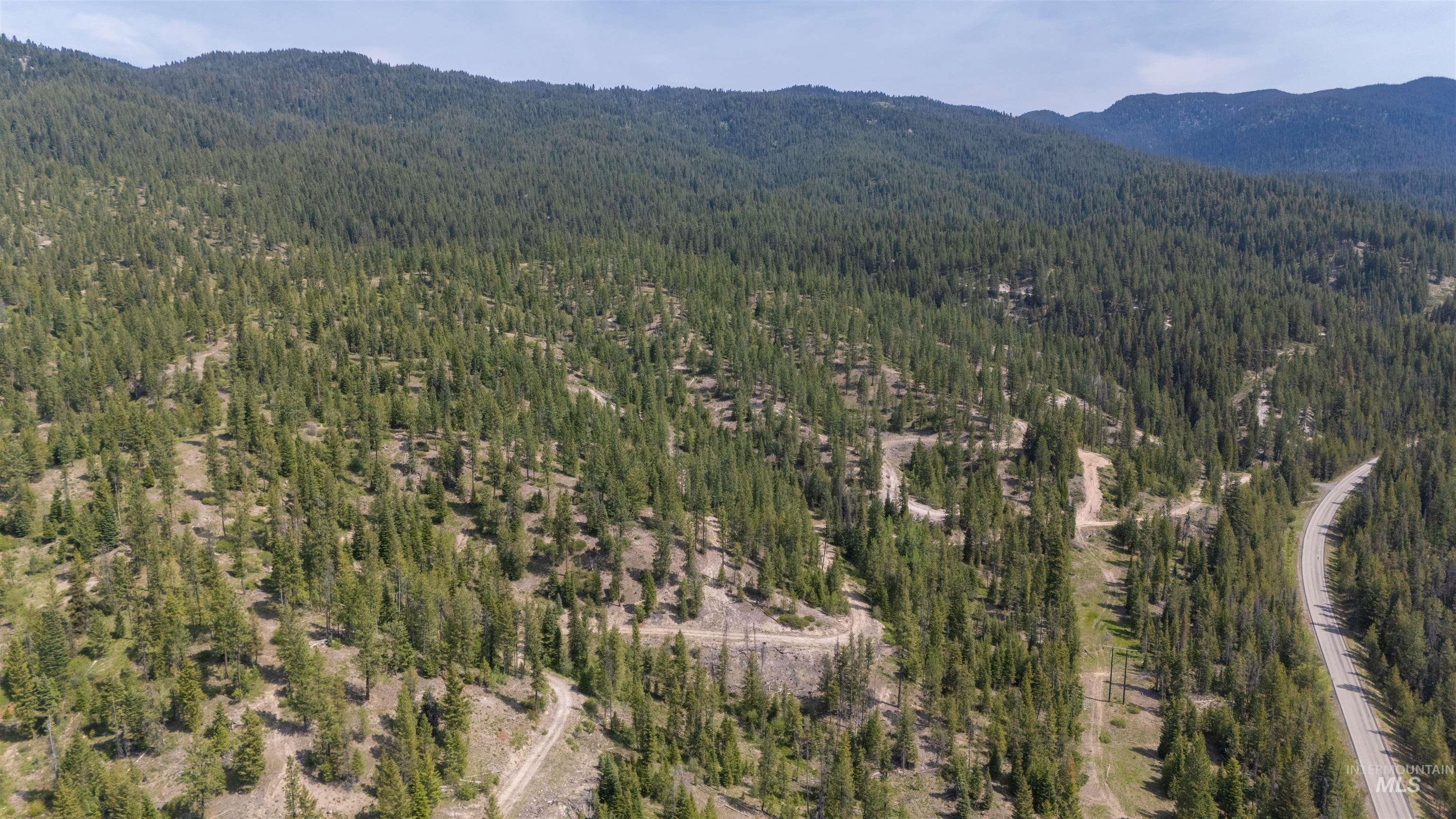 4 Warm Lake Road Cascade, ID 83611 - Photo 1 of 8 Aerial overview of property's location with a heavily wooded area and a mountainous background