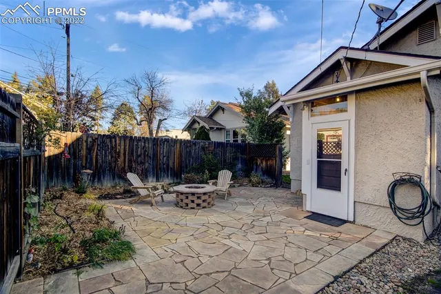 a view of a patio with table and chairs with wooden fence and plants