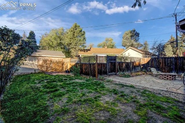 a view of a house with a yard and wooden fence