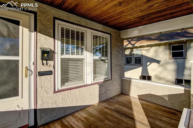 a view of a porch with wooden floor and iron stairs