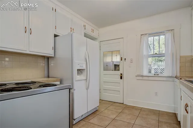 a kitchen with white cabinets and white appliances