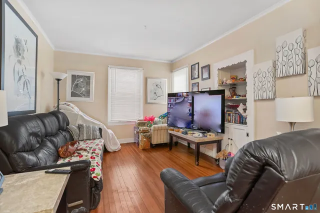 a view of a hallway with wooden floor and stairs