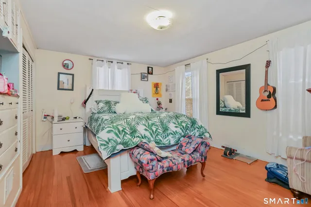 a bedroom with a bed and wooden floor