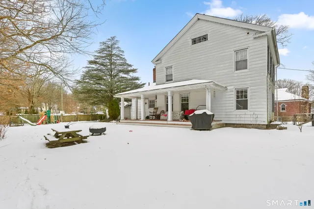 a view of a house with snow on the side of road