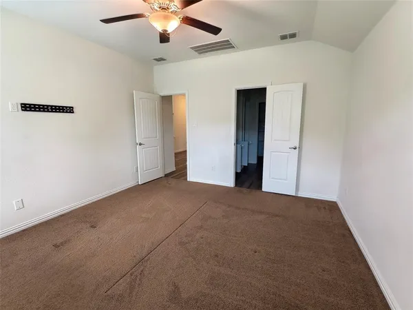 a view of a big room with closet and a ceiling fan