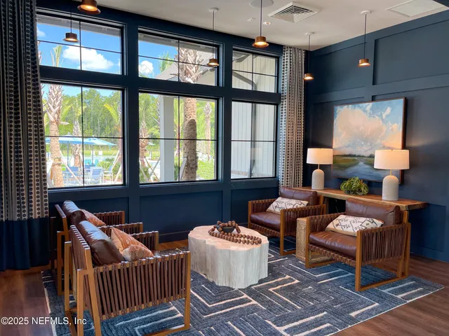 a living room with furniture and floor to ceiling windows