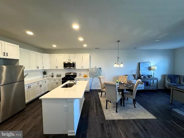 a kitchen with a table chairs a refrigerator and a stove