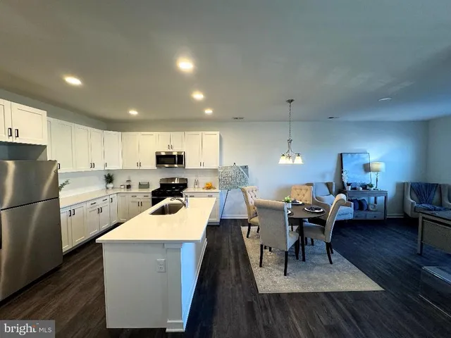 a kitchen with a table chairs a refrigerator and a stove