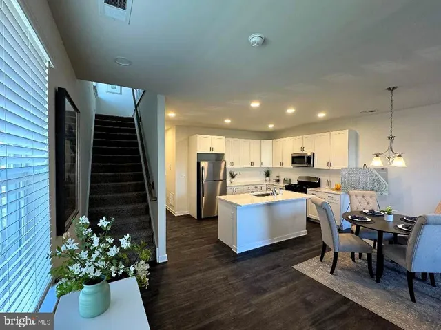 a living room with kitchen island furniture and a potted plant