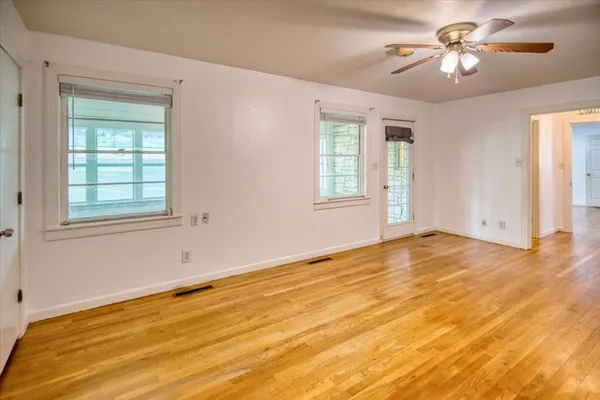 a view of empty room with a window and chandelier fan