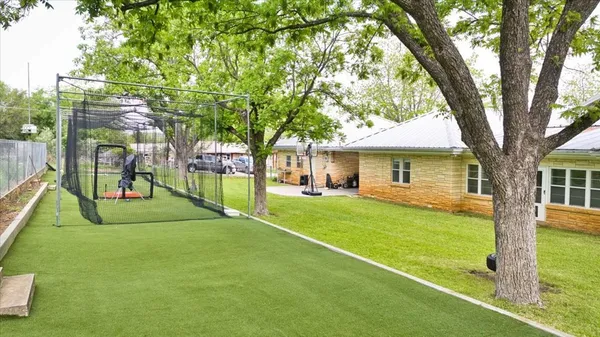 a view of a house with a backyard and a tree