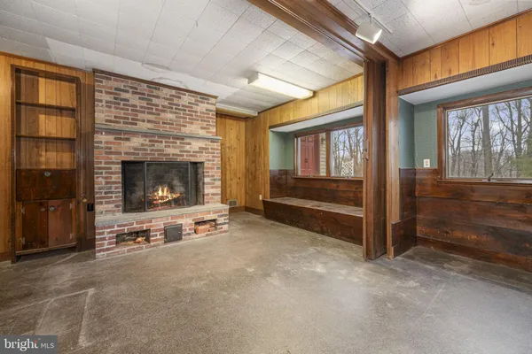 a view of an empty room with fireplace and a window