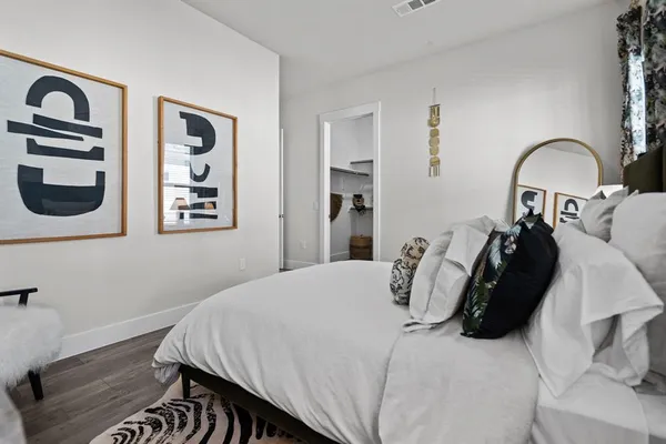 a bedroom with a bed and a painting on the wall