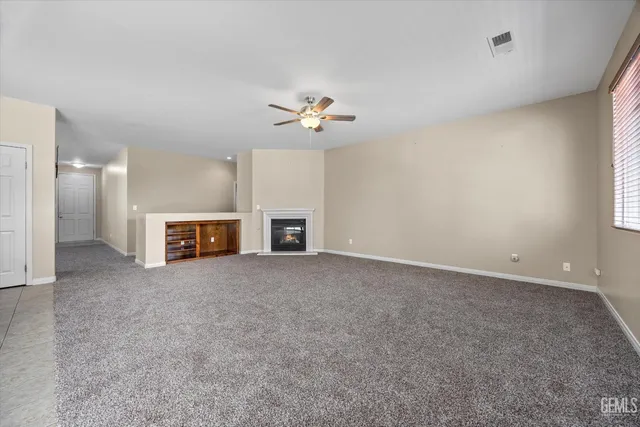 an empty room with fireplace and a window