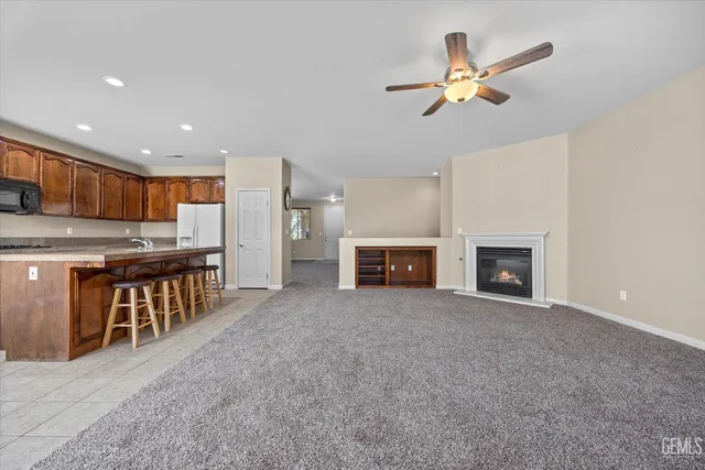 a view of an empty room with a fireplace and window