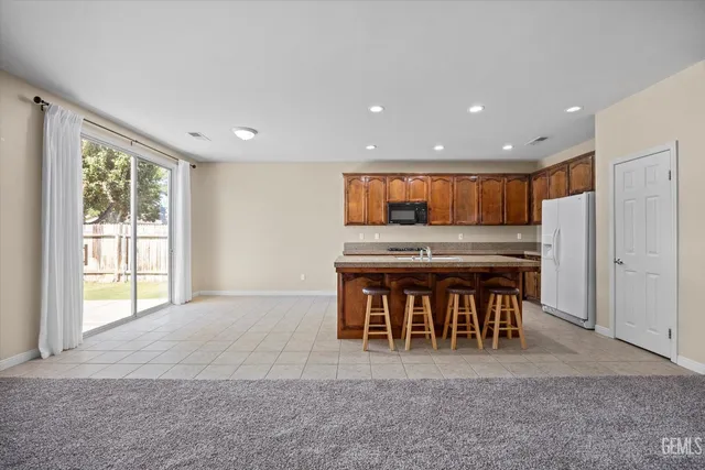 a kitchen with stainless steel appliances granite countertop a stove a sink and a refrigerator