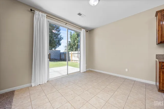 a kitchen with stainless steel appliances granite countertop a table chairs sink and cabinets