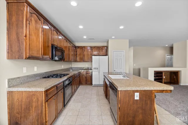 a kitchen with stainless steel appliances granite countertop a refrigerator sink and cabinets