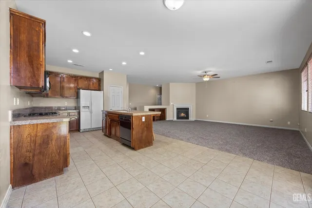 an empty room with chandelier fan and windows